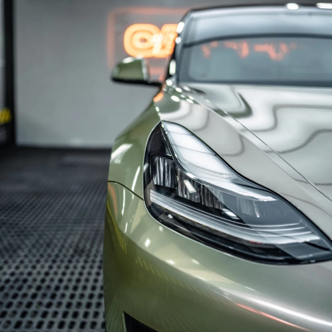 A sports car with Alpine Green paint protection film colored wrap is parking in the garage