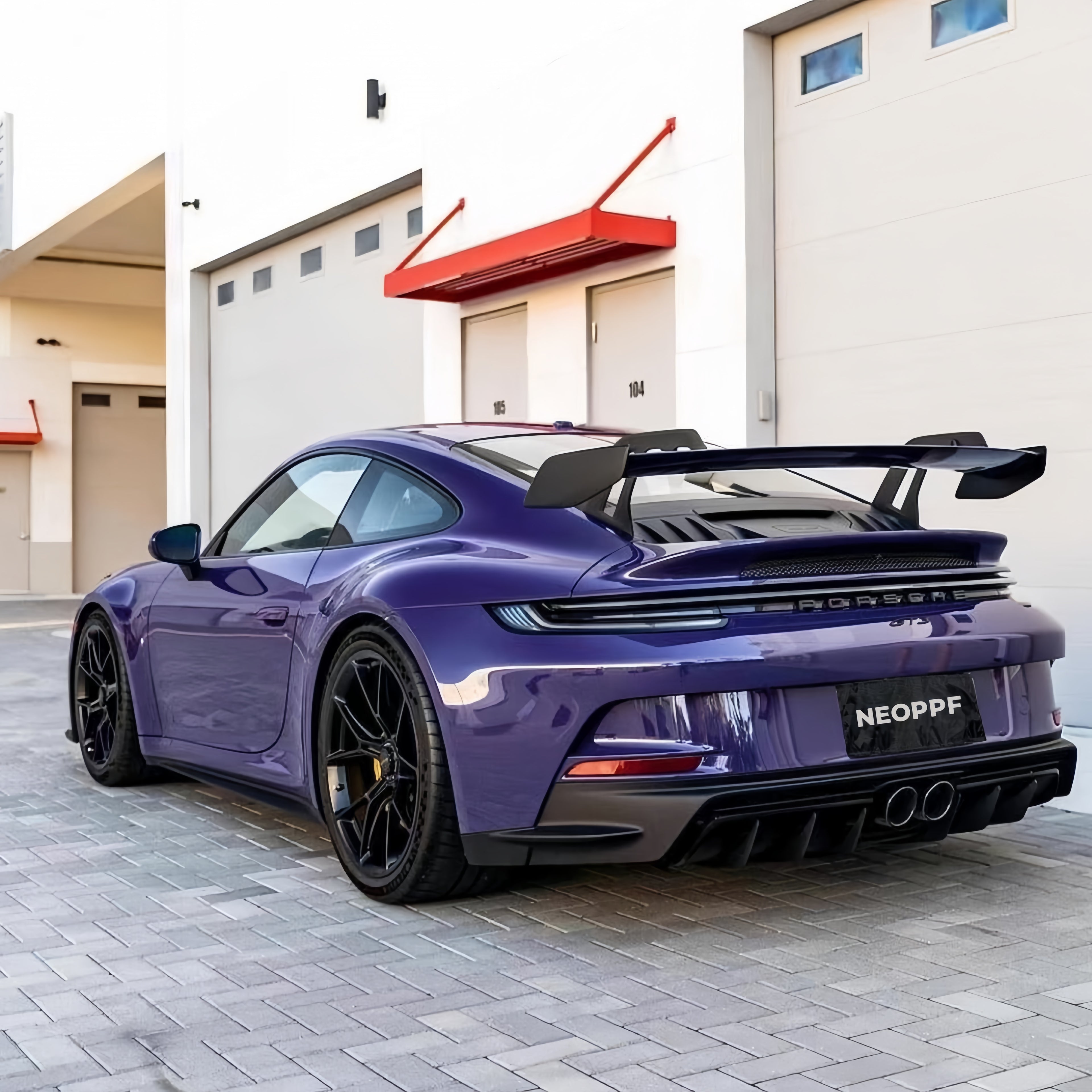 A sports car with GT Violet paint protection film colored wrap is parking in the garage