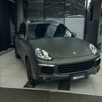 A sports car with Matte Mysterious Green paint protection film colored wrap is parking in the garage