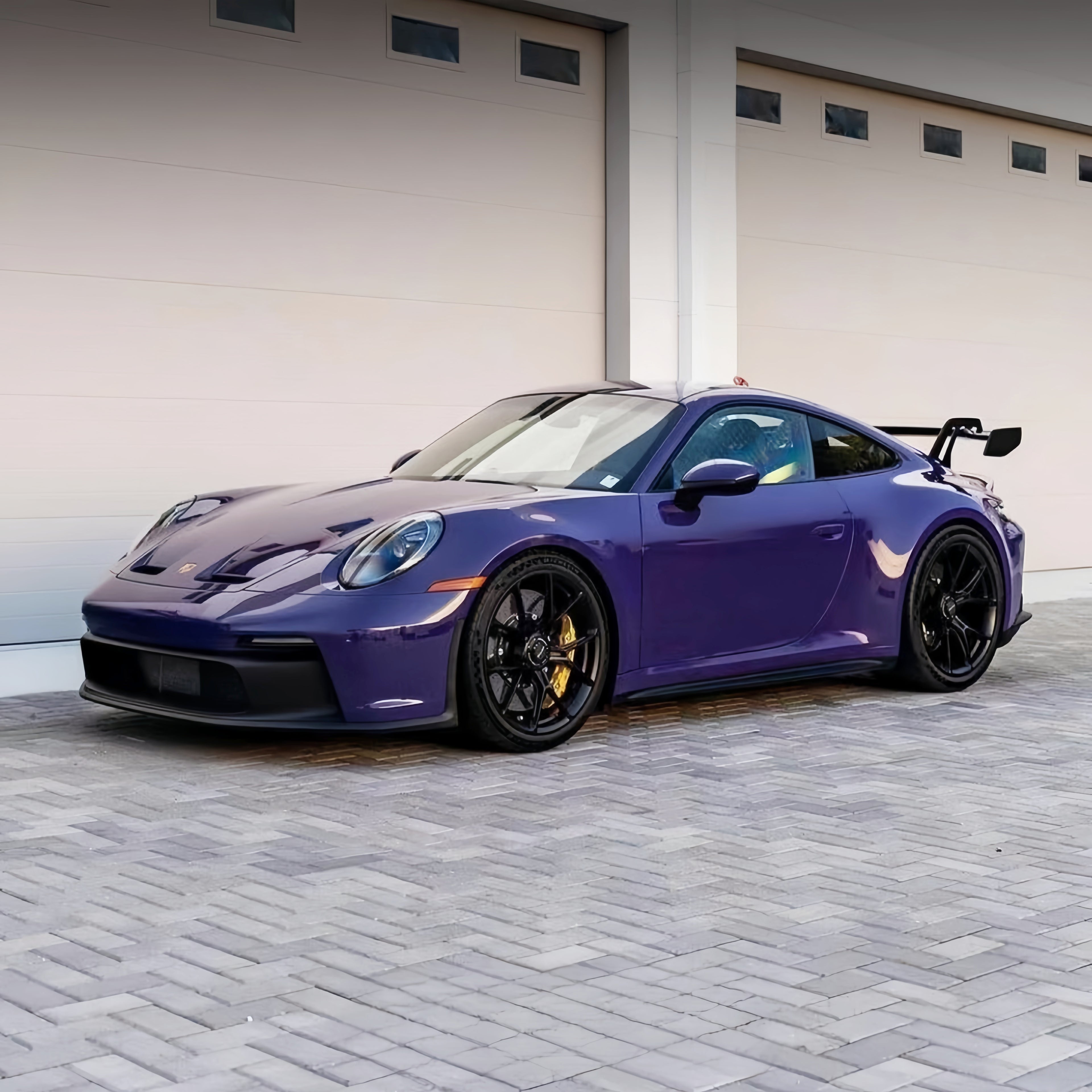 A sports car with GT Violet paint protection film colored wrap is parking in the garage