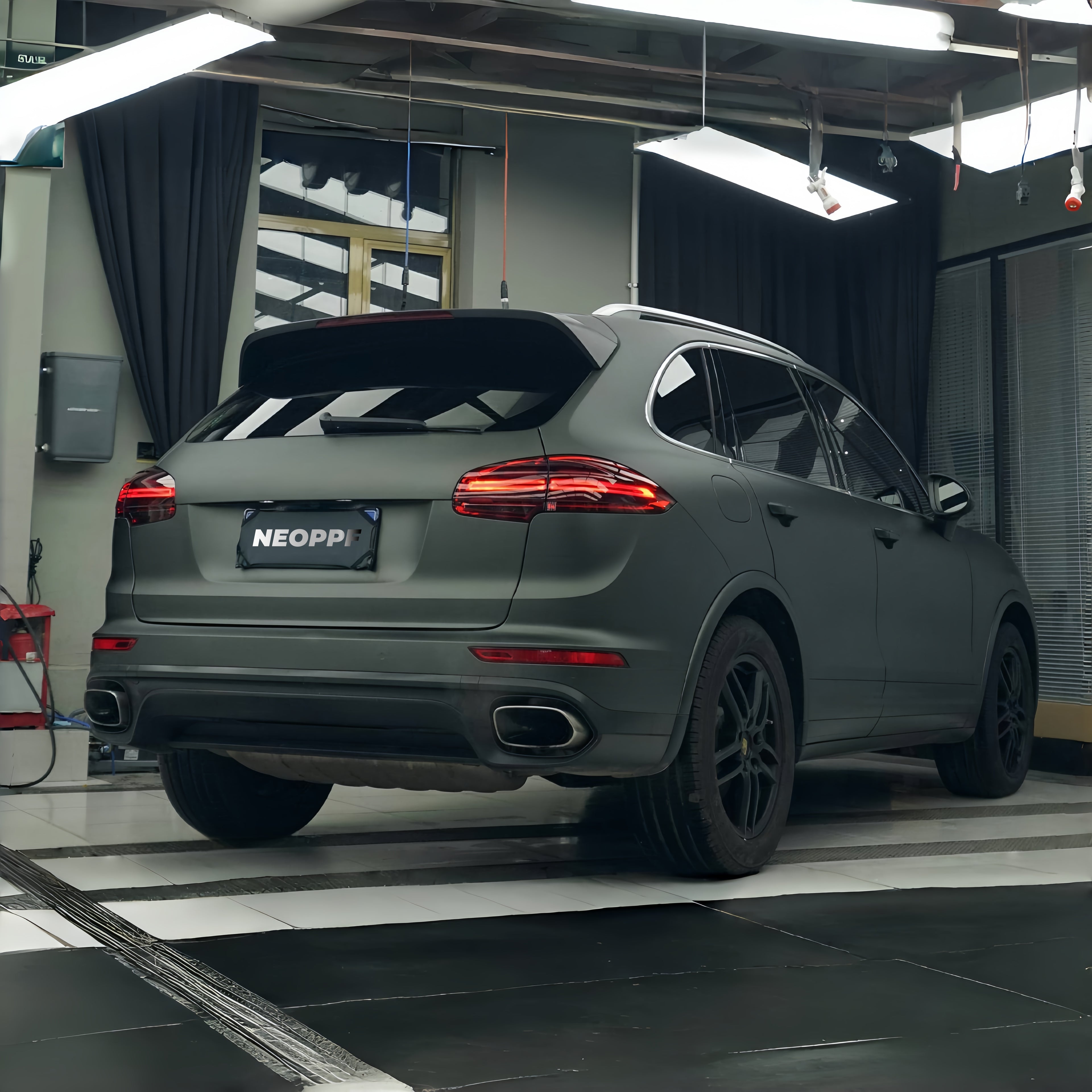 A sports car with Matte Mysterious Green paint protection film colored wrap is parking in the garage