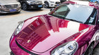 A sports car with Glazed Tata Red paint protection film colored wrap is parking in the garage