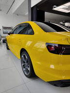 A sports car with Signal Yellow paint protection film colored wrap is parking in the garage