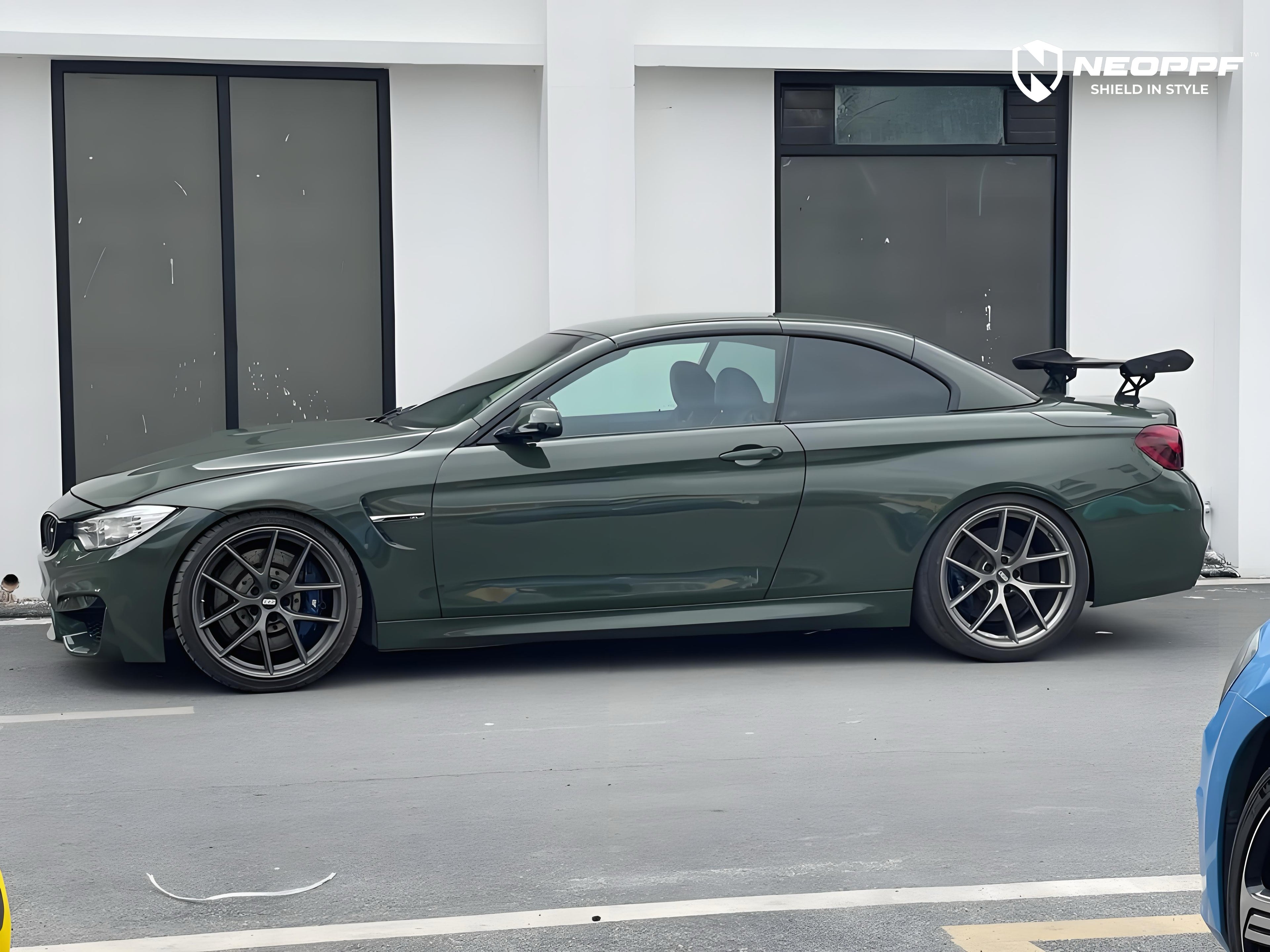 A sports car with British Green Metallic paint protection film colored wrap is parking in the garage