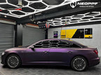 A sports car with Satin Pinot Noir Purple paint protection film colored wrap is parking in the garage