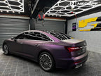 A sports car with Satin Pinot Noir Purple paint protection film colored wrap is parking in the garage